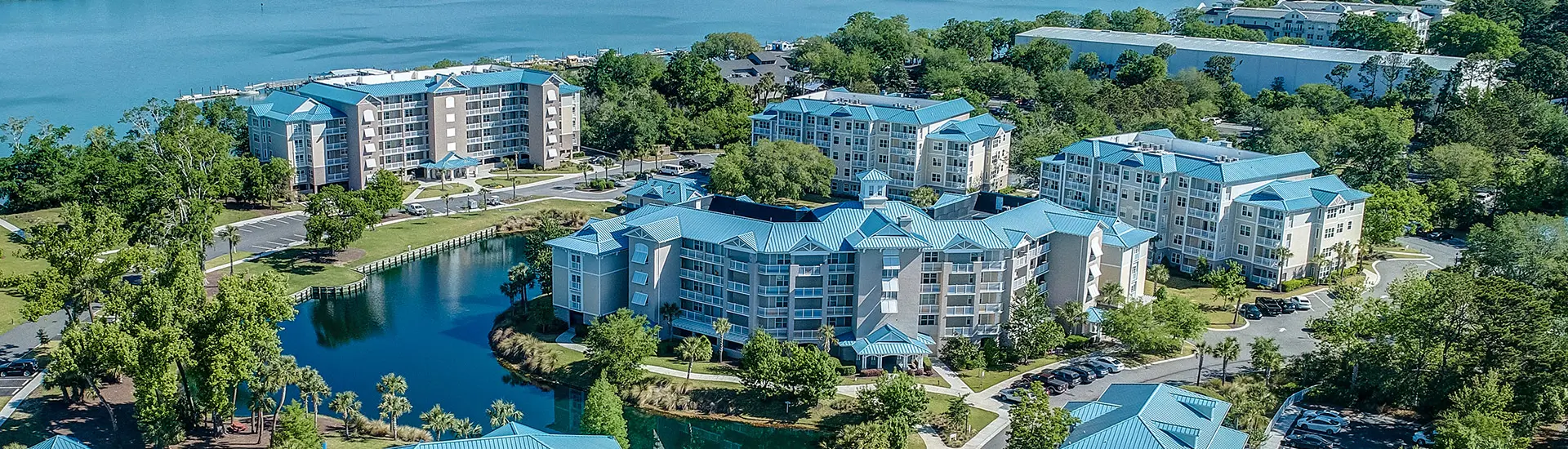Aerial view of Bluewater Resort and Marina by Spinnaker Resorts on Hilton Head Island, featuring luxury villas with bright blue rooftops, set along the serene Intracoastal Waterway.